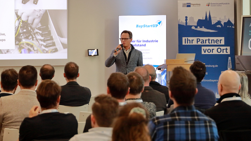 Matthias Lodes von SKP Technik hält seinen Impulsvortrag. Im Vordergrund ist das Publikum mit Blick nach vorne zu sehen.